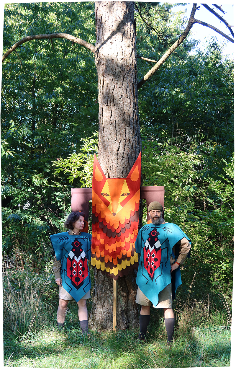 En hemmelig klub i spejderkostumer inspireret af Kibbo Kift Kindred foran et rævetotem, på en bavnehøj på Mols. Udenfor billedet brænder Studstrupværket i baggrunden